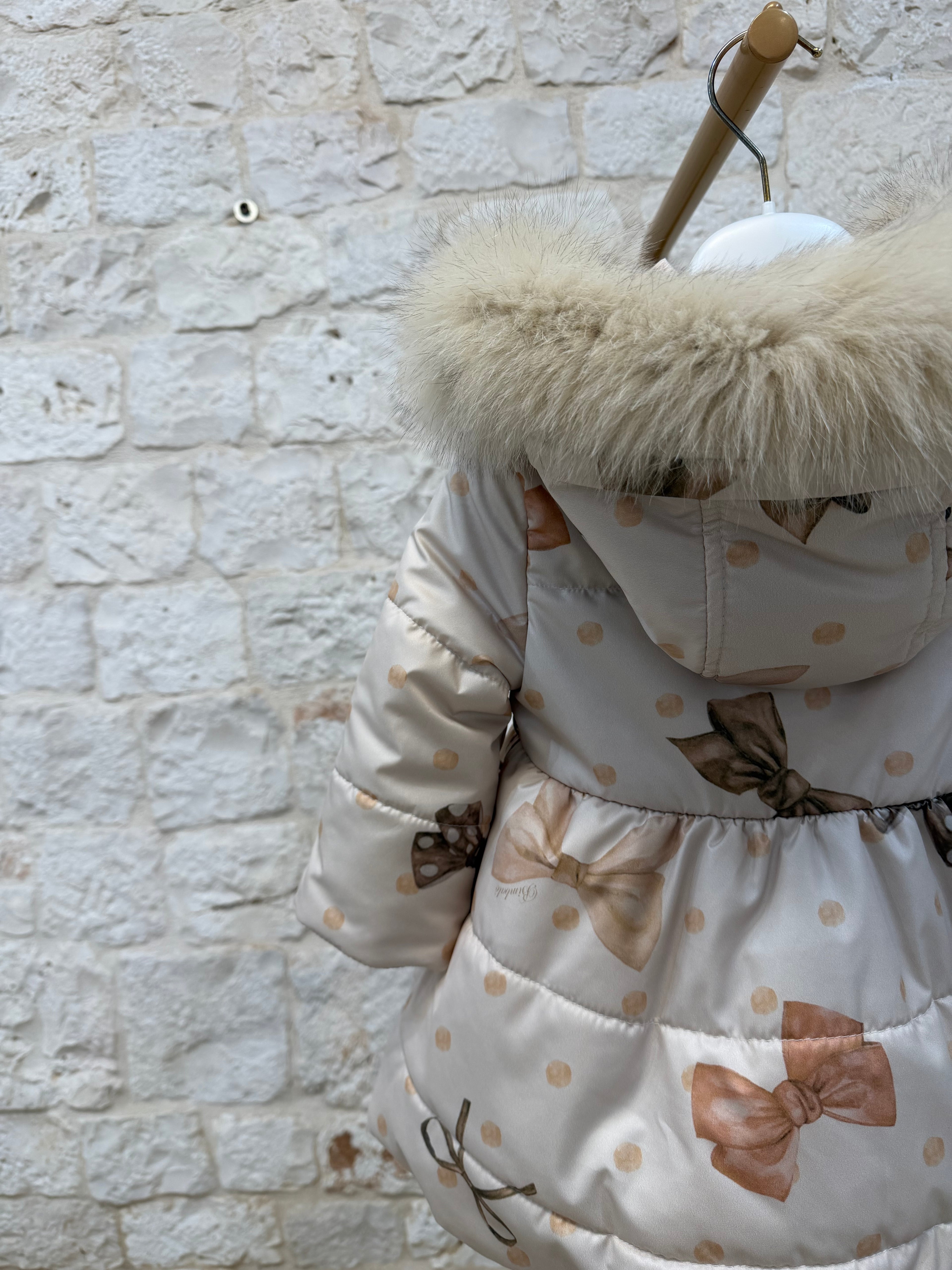 Piumino bimba beige fiocchetti cappuccio pelliccia Bimbaló | VIA32